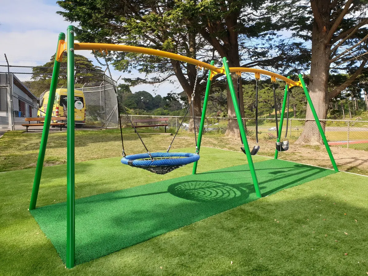 Basket swing and infant swings on artificial turf at Newtown Park playground, Wellington