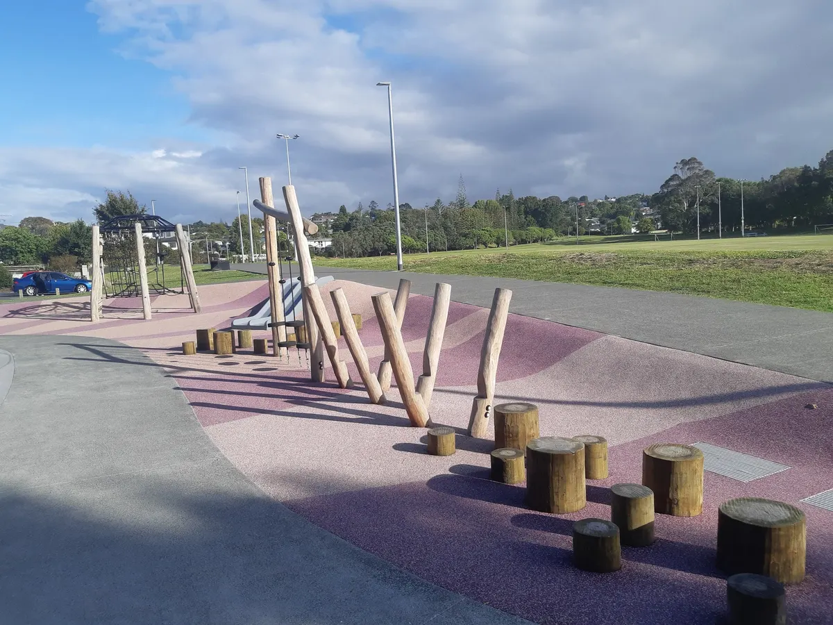 Slalom poles and timber balance logs on rubber surfacing at Sunnynook Park playground, Auckland