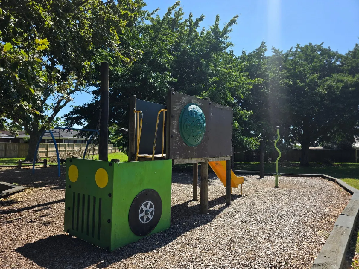 Wooden play structure with slide on bark at Jutland Road South playground, Pukekohe