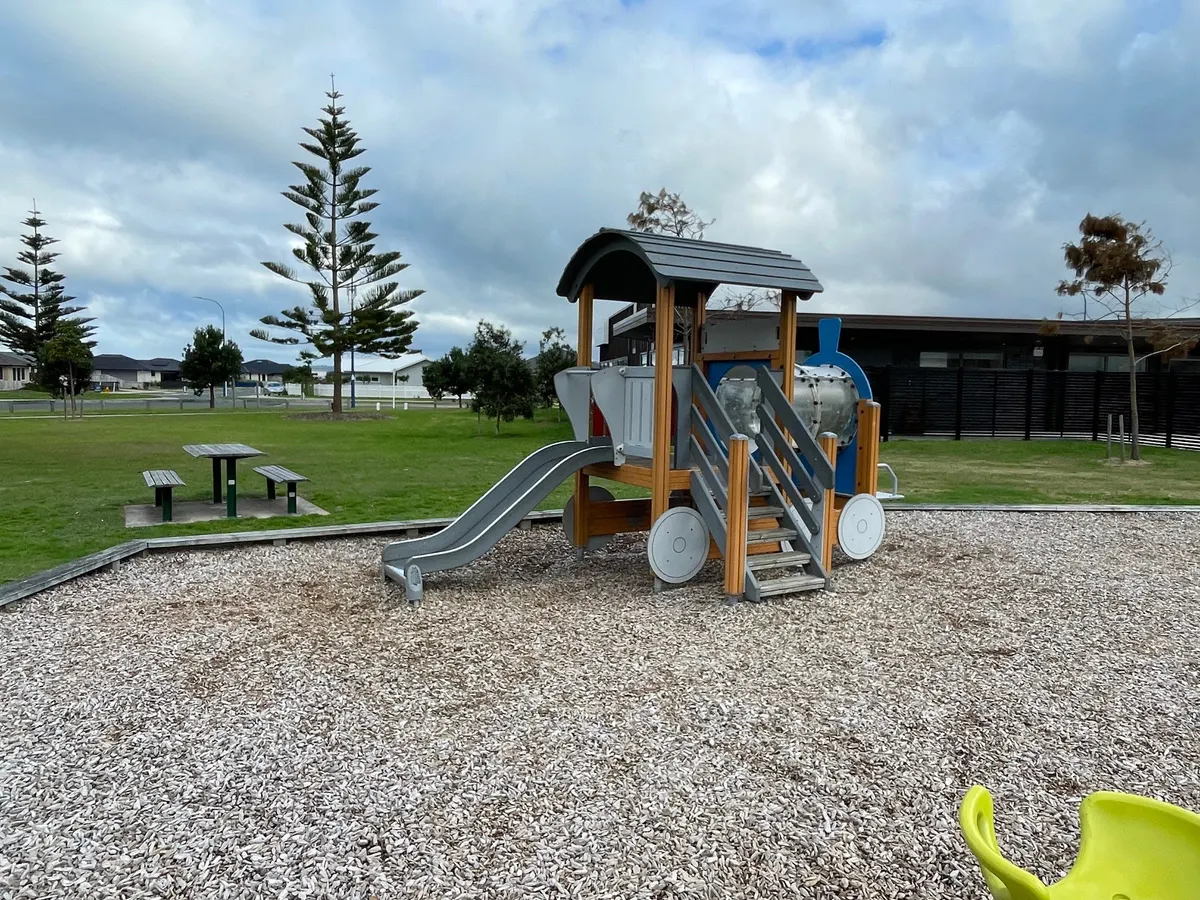 Train-style play tower with slide and picnic table at Harding Reserve playground, Papamoa Beach
