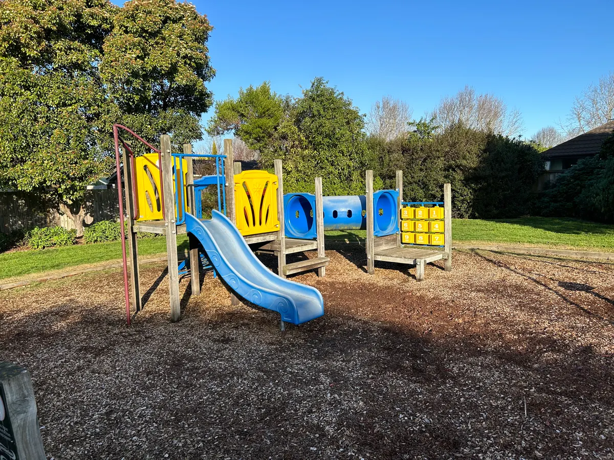 Blue slide and tunnel play structure on bark at Calbreath Reserve Playground, Russley, Christchurch