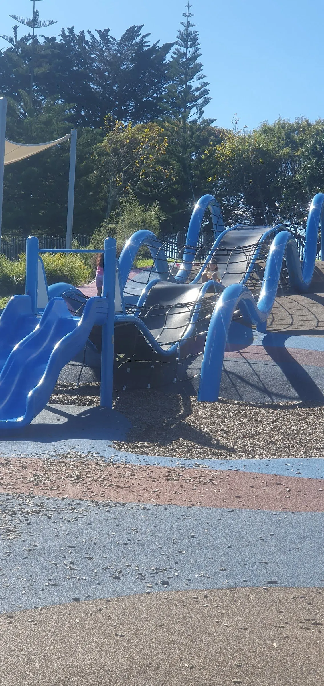 Blue wave climbing structure with nets and slide at Mangere Centre Park playground, Māngere East