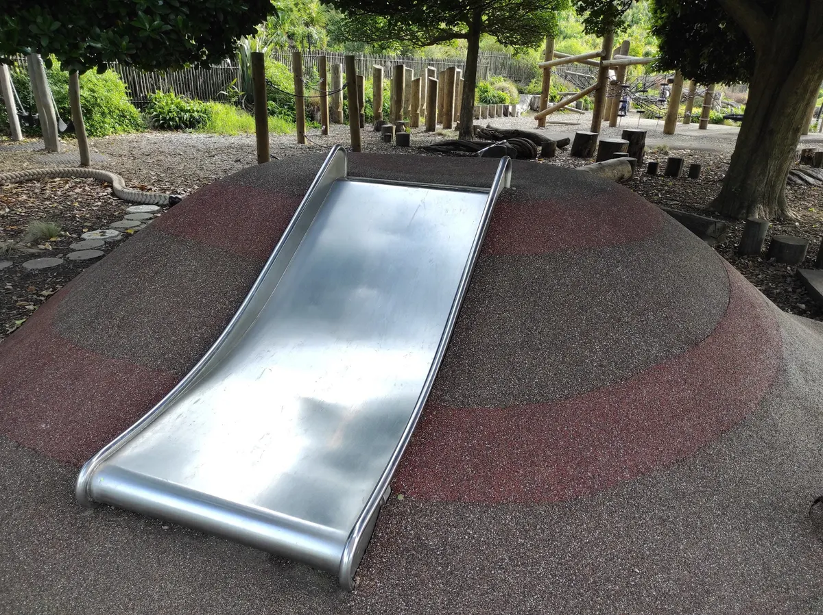 Silver embankment slide on a rubber mound at Mangere Domain Playground, Māngere Bridge