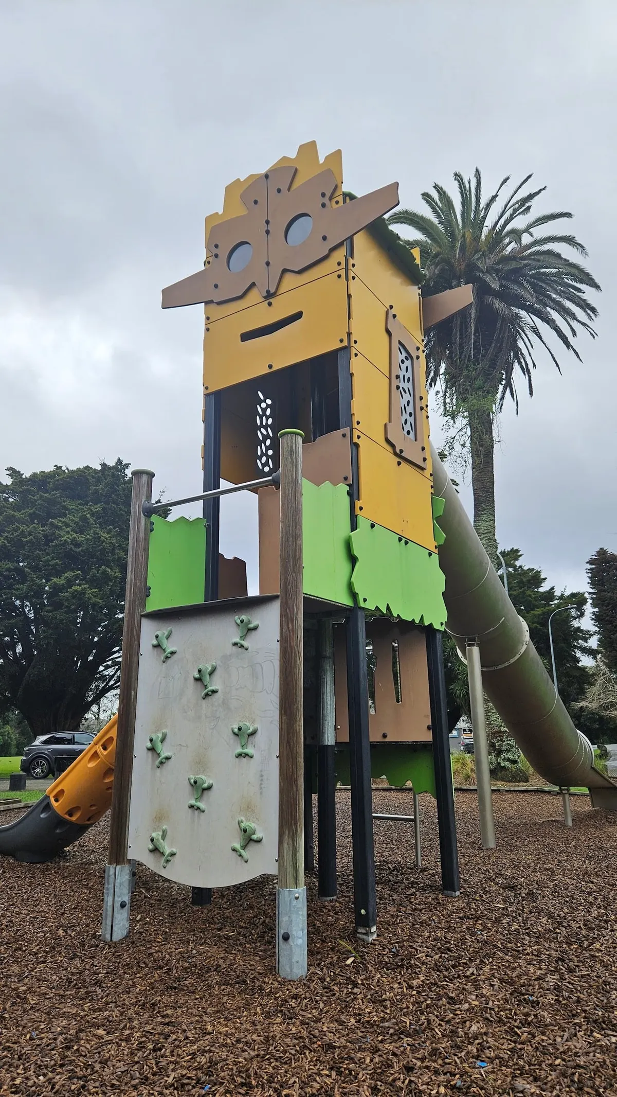 Tall yellow and green play tower with a long tube slide at Gribblehirst Park playground, Sandringham