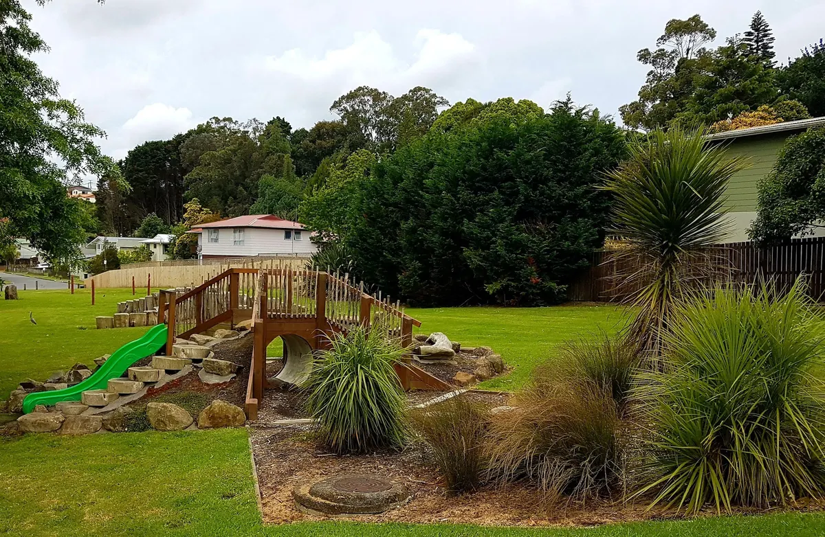 Green slide, timber bridge and rocks at Cresta Park playground, Onerahi, Whangārei