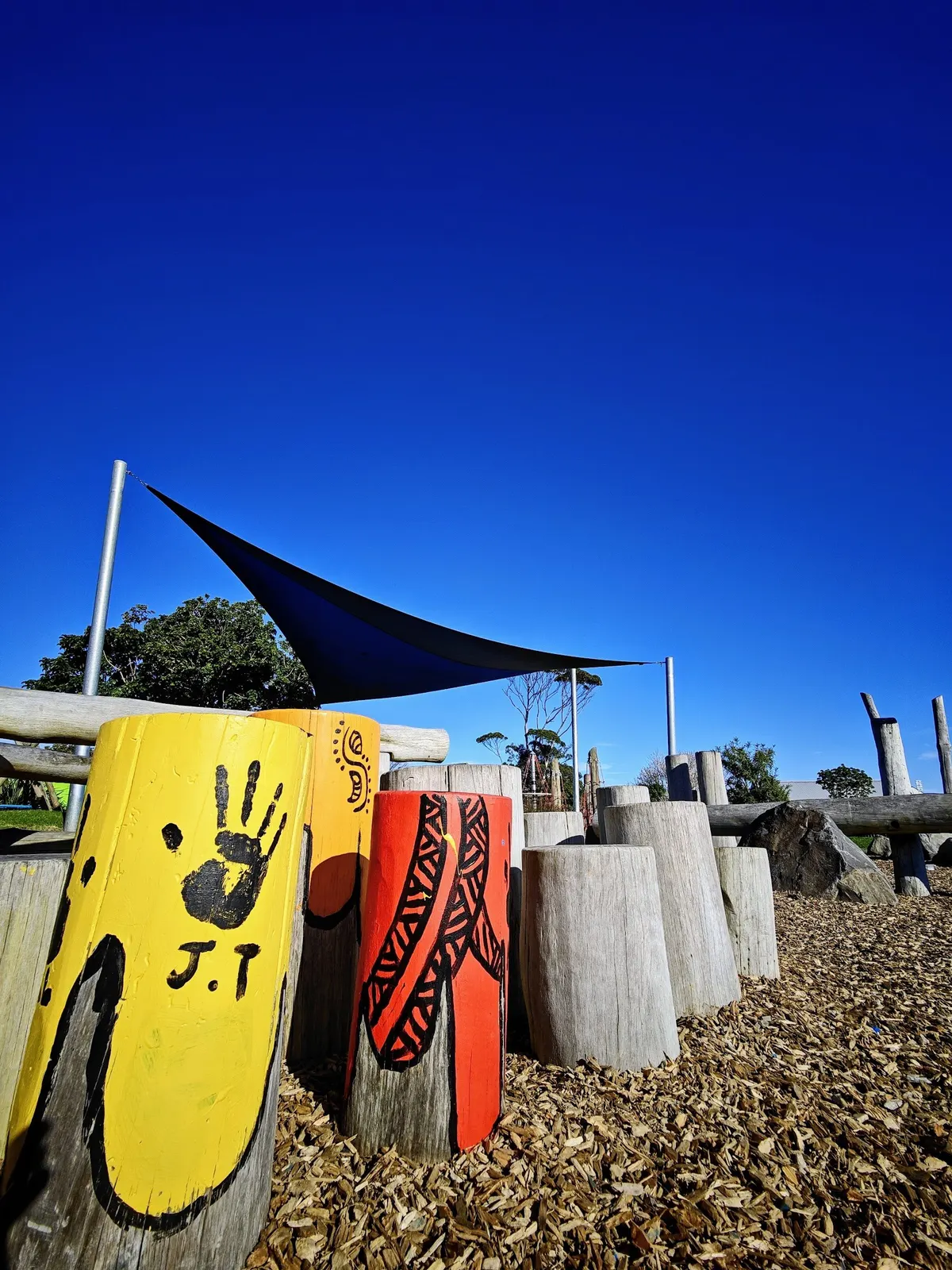Painted log stumps and a shade sail at WIRI Playground, Wiri, Auckland
