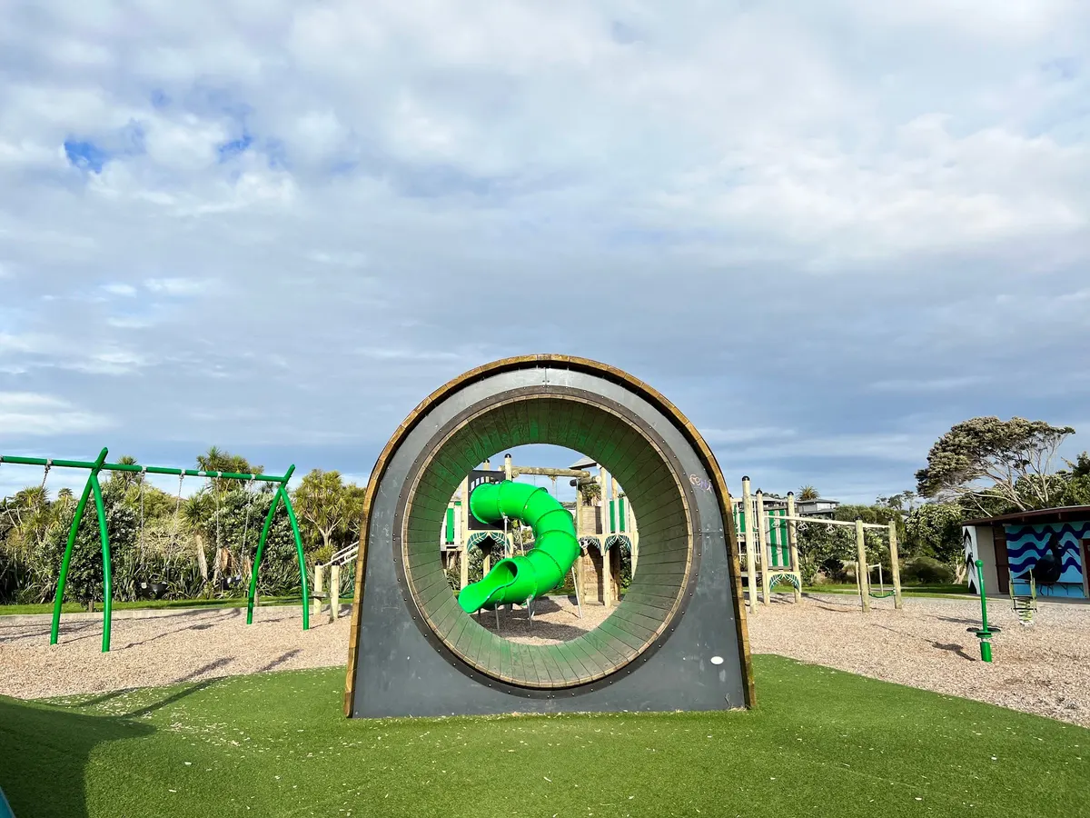 Giant hamster wheel with a green tube slide behind at Eric Armishaw Park playground, Point Chevalier