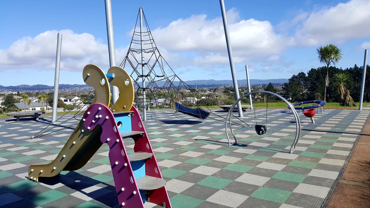 Slide, rope climbing pyramid and swing hoop at Heron Park playground, Waterview