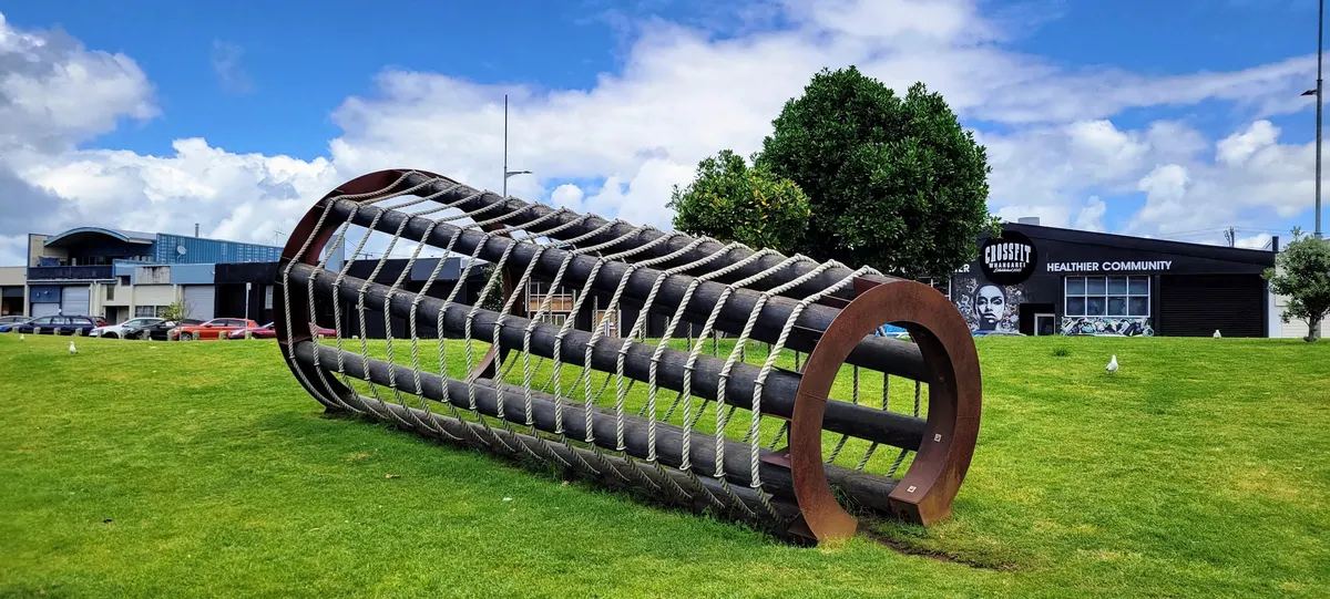 Rope-and-log climbing tube on the lawn at Hihiaua Park playground, Whangārei Town Basin