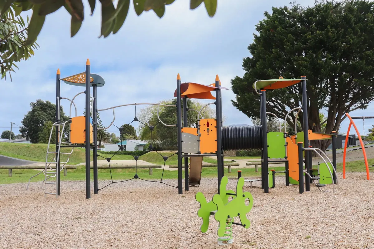 Multi-play tower with tunnel and a spring toy on bark at Te Atiawa Park playground, Paraparaumu Beach