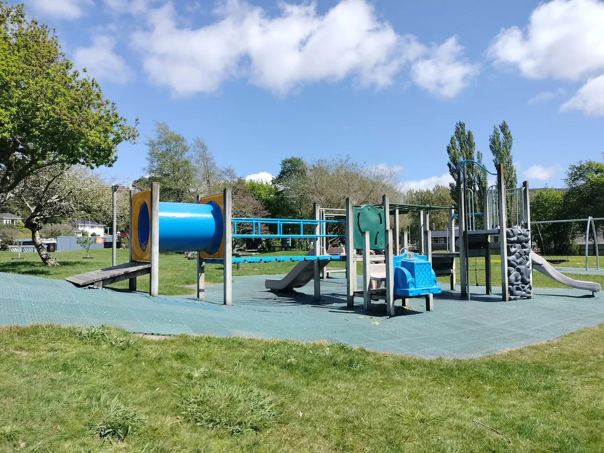 Blue tunnel, slides and climbing wall on the play structure at Thomas St Playground, Stokes Valley
