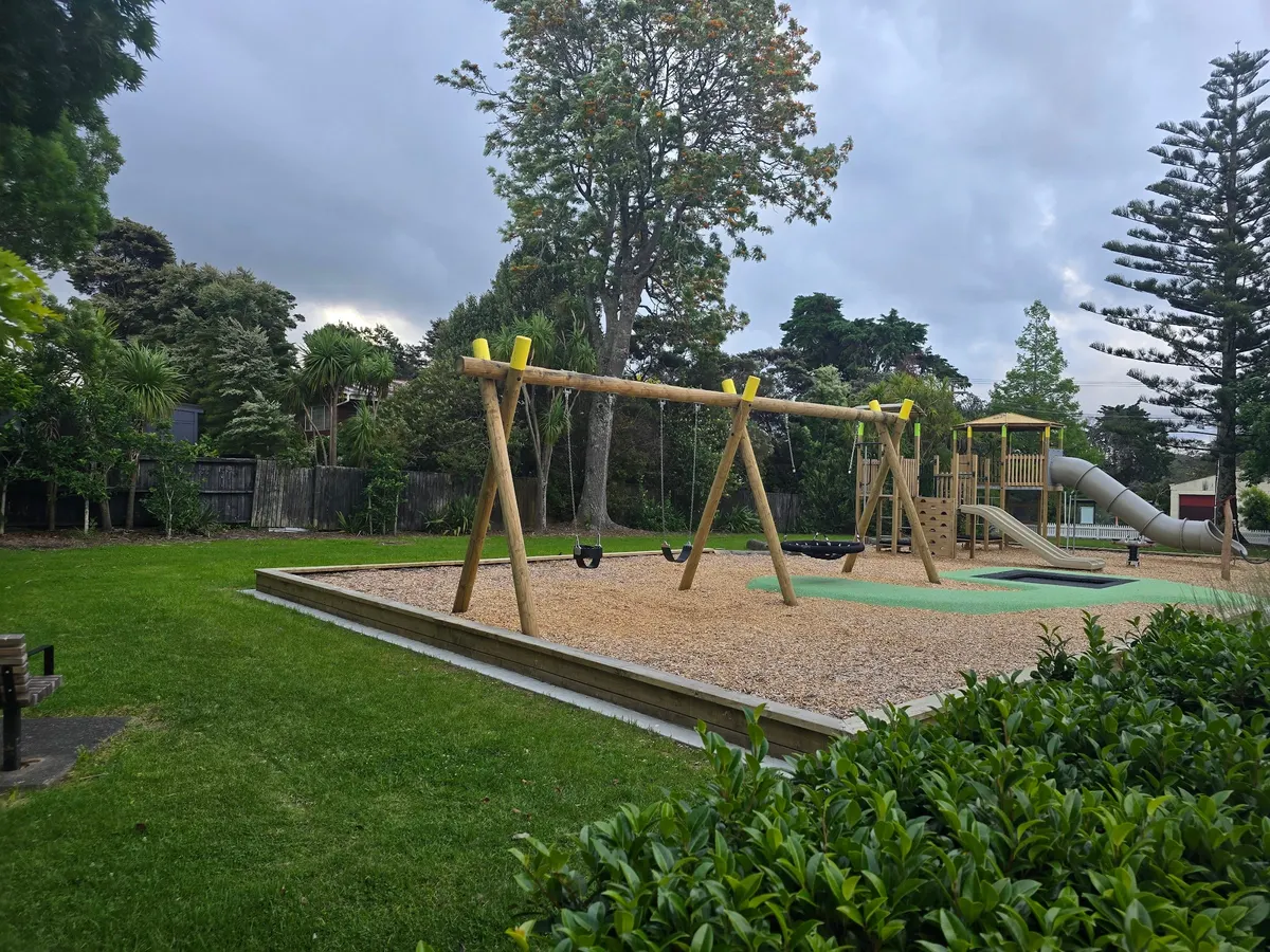 Hammock swing, timber swing frame and slides on bark at Collins Park playground, Greenhithe
