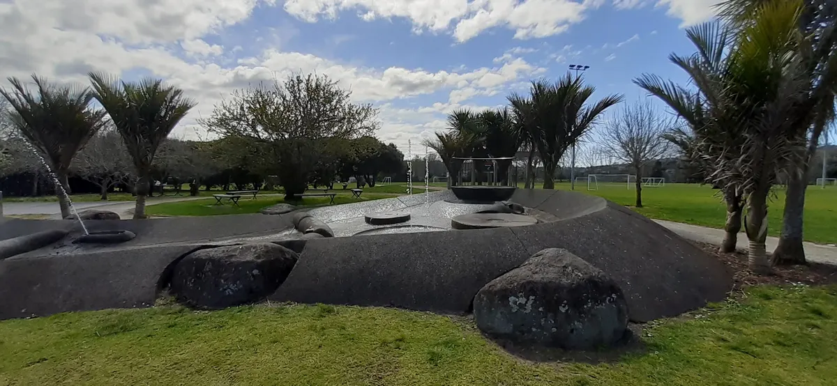 Rock-lined water play area with fountains at Wainoni Park playground, Greenhithe