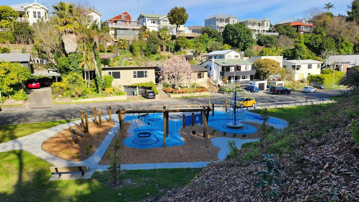 Blue rubber surfacing, spinner and swing frame at Gleeson Park playground, Hospital Hill, Napier