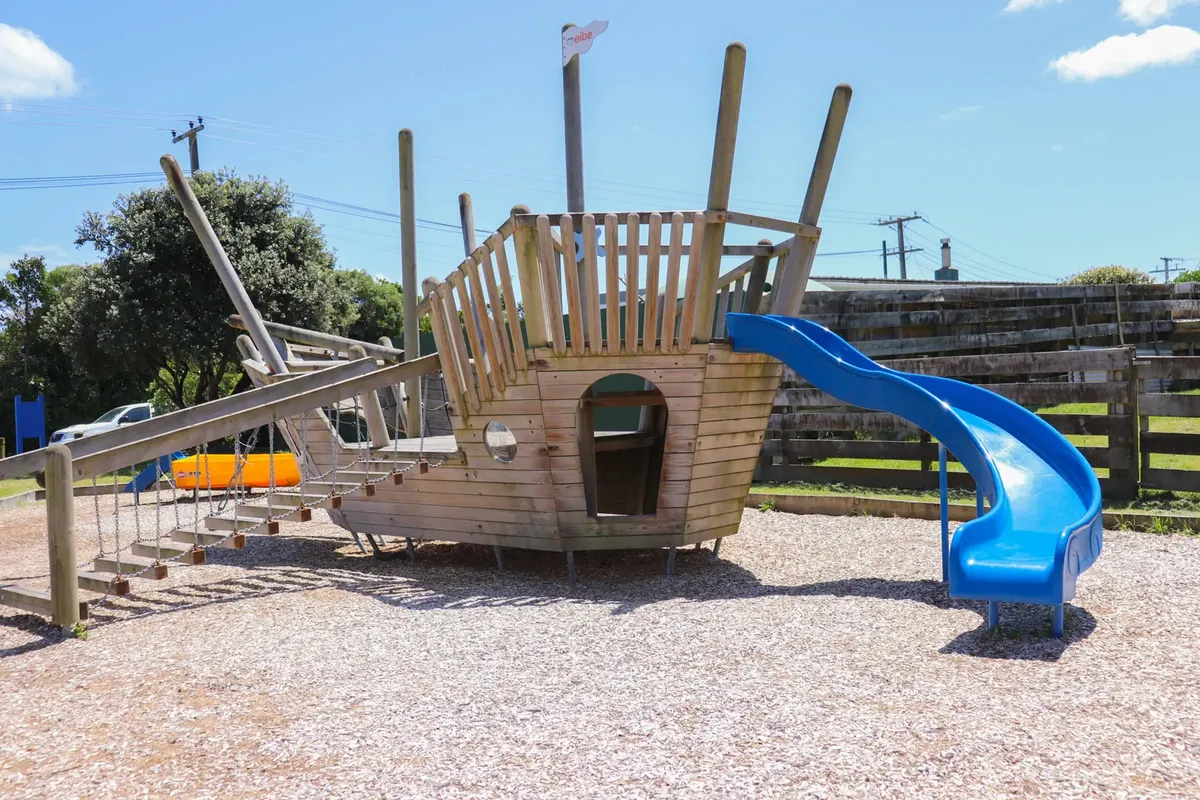 Wooden pirate ship play structure with blue slide at Dixie Street Park playground, Te Horo Beach