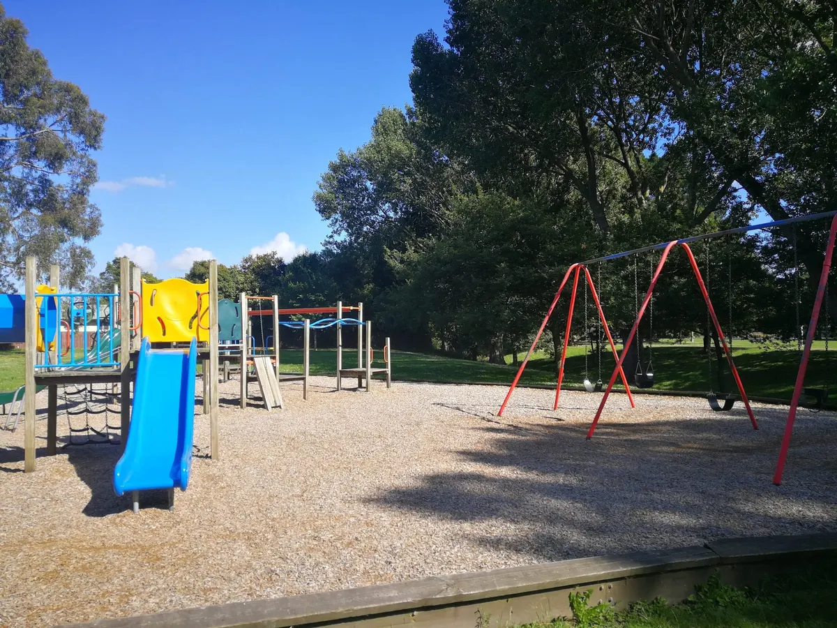 Blue slide, multi-play structure and red swing set at Crosbie Park playground, Avonhead