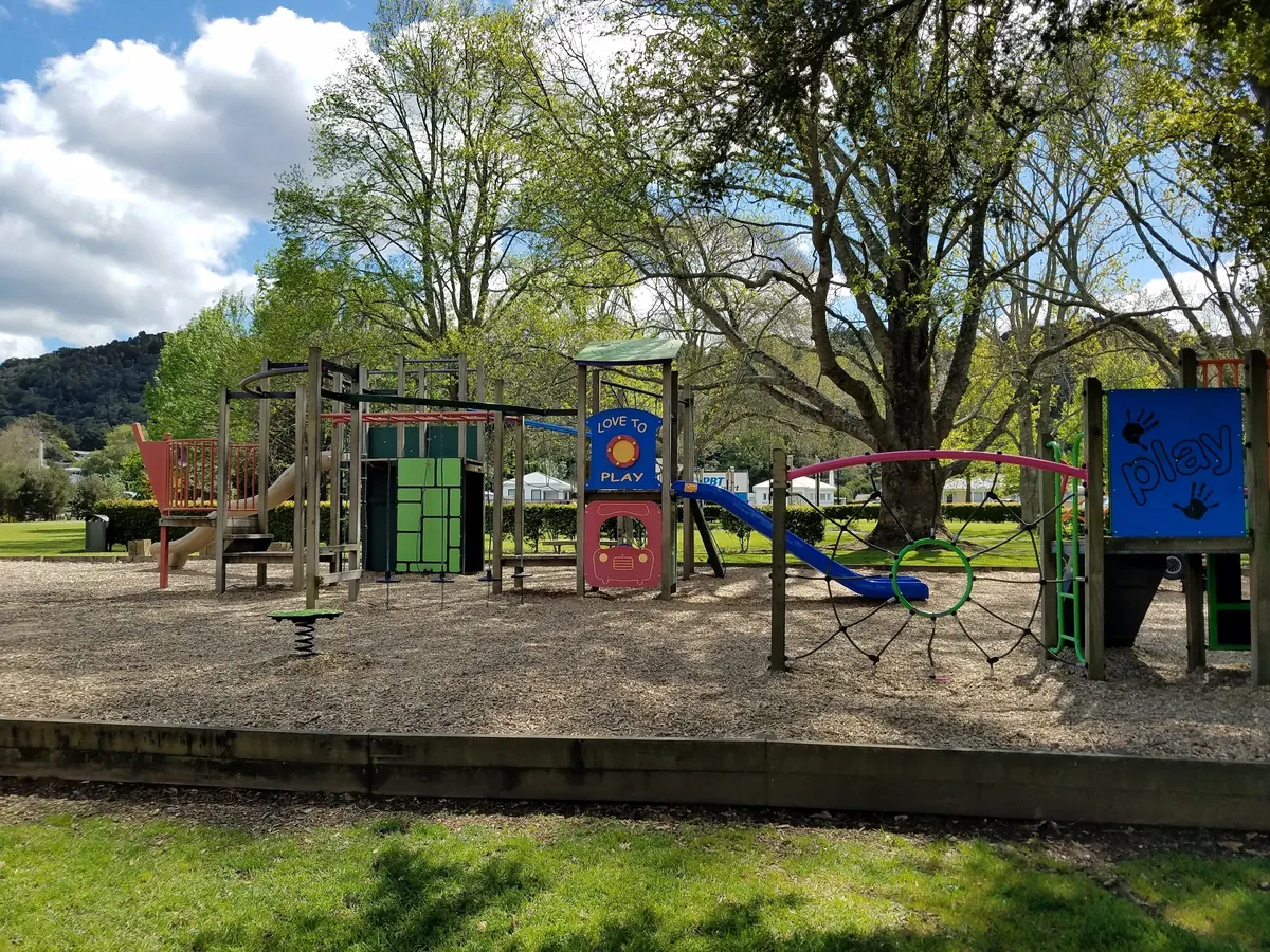 Junior multi-play tower with slides and a spring rocker on bark at Mander Park playground, Whangarei