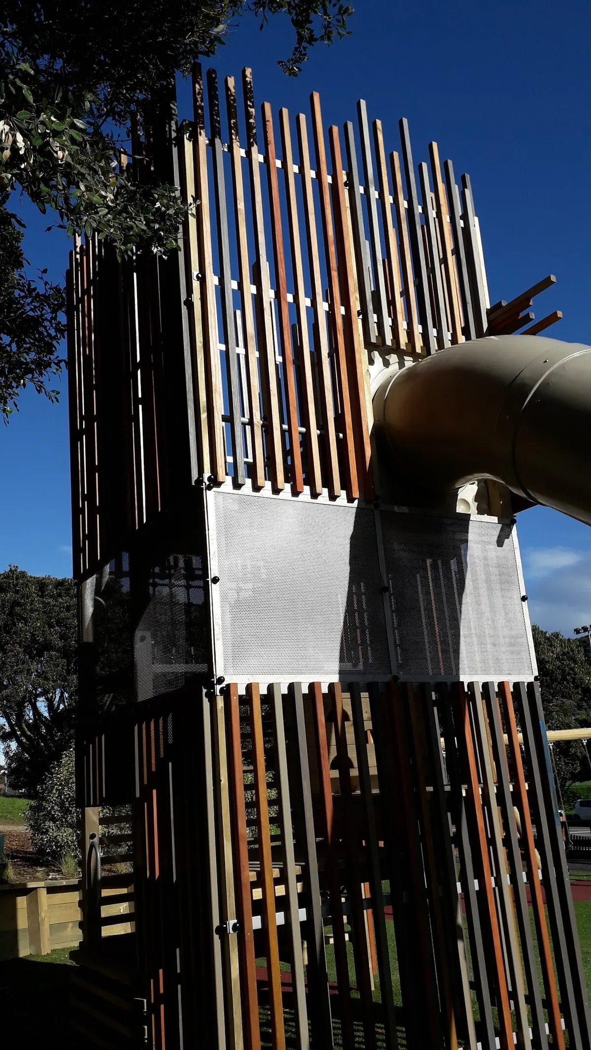 Slatted timber tower with a tubular slide at Wakefield Park playground, Island Bay
