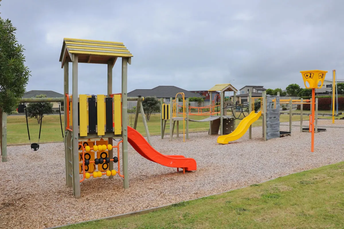 Slides, climbing frame and play structures on woodchip at Pharazyn Avenue playground, Waikanae Beach