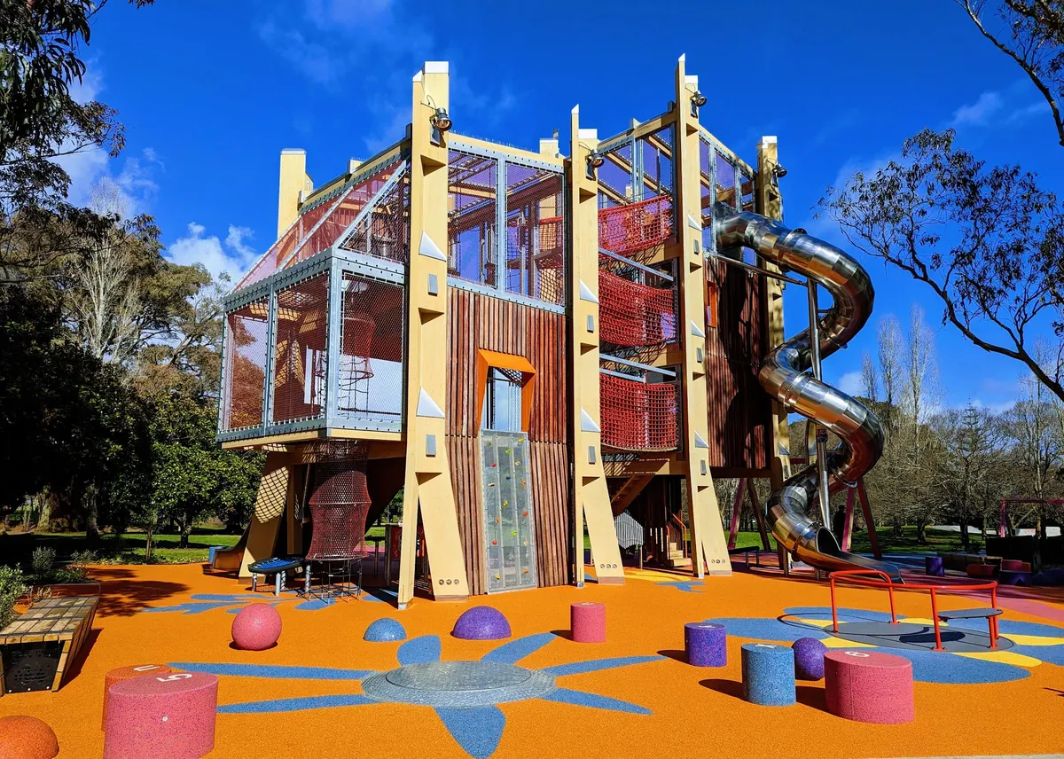 Tall timber play tower with steel spiral slide at Hayman Park playground, Manukau