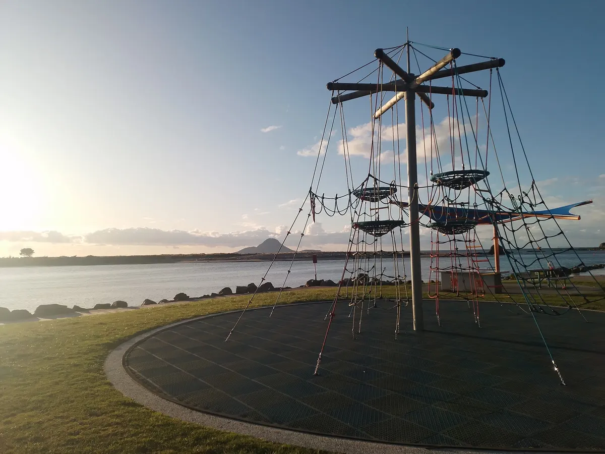 Rope eagles nest climber on rubber matting beside the Whakatāne harbour at Wairaka Centennial Park playground