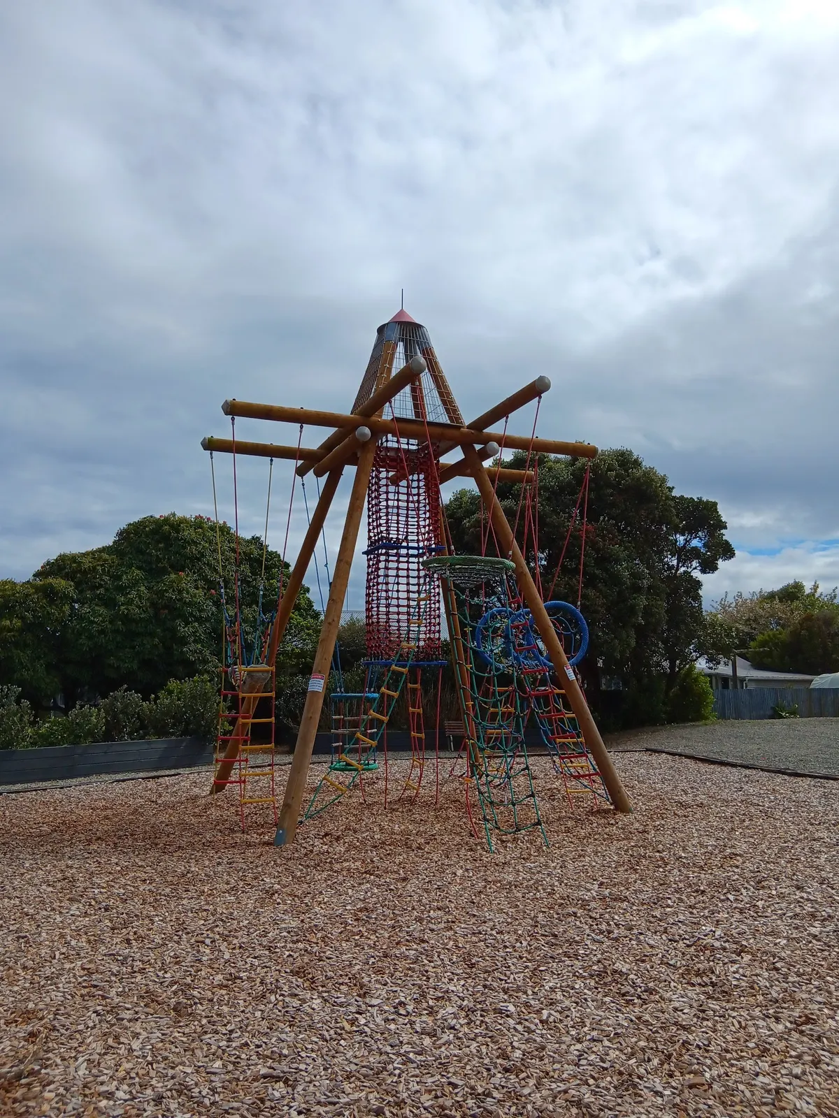 Rope and net climbing tower on a bark surface at Lazar Park playground, Hokitika