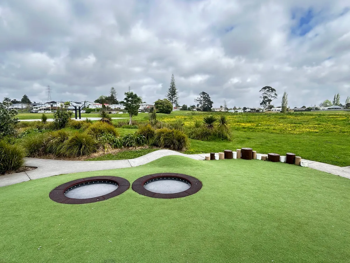 In-ground trampolines on a turfed mound at Archibald Park playground, Kelston, Auckland