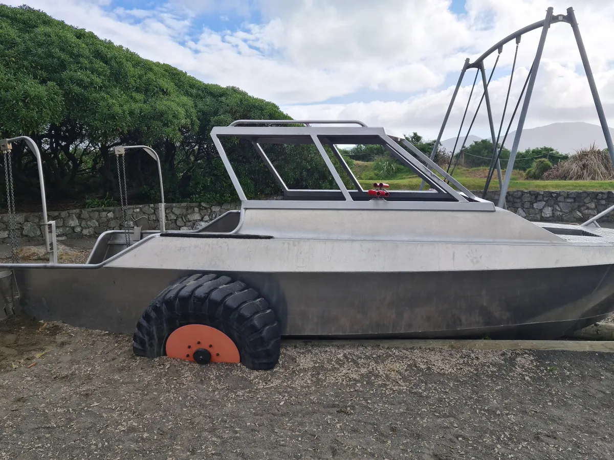Metal boat on wheels beside a swing frame at MacLean Park playground, Paraparaumu Beach