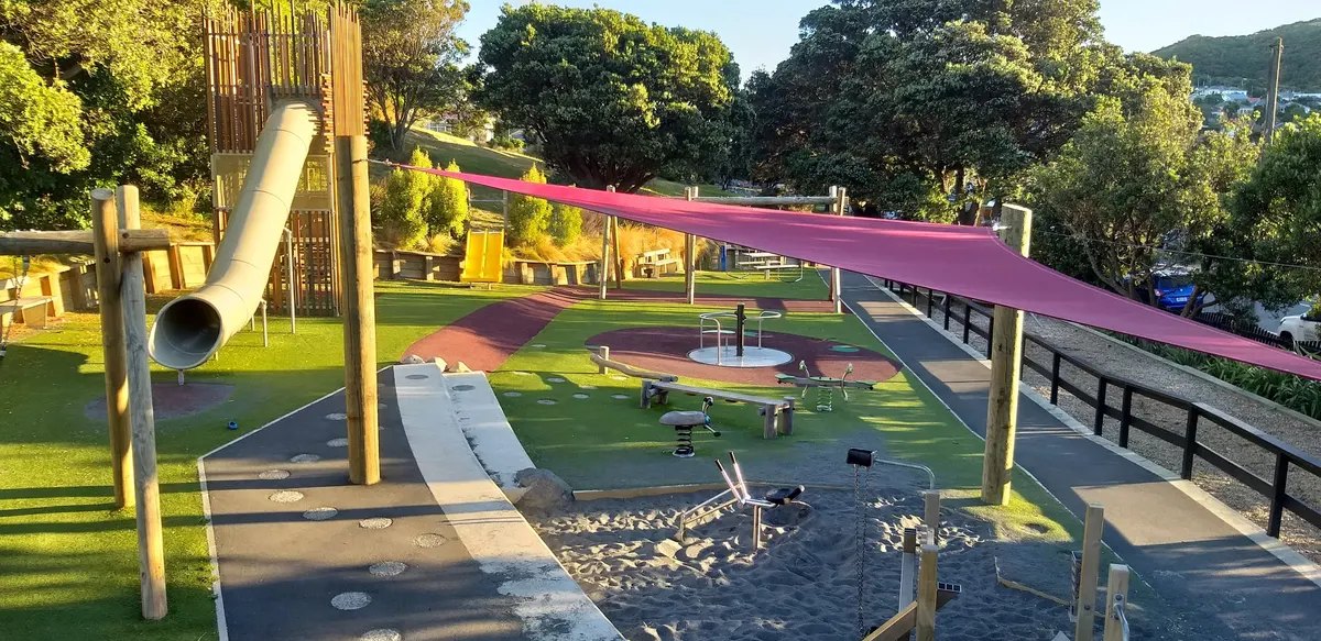 Tube slide, sand play under a shade sail and swings at Island Bay Playground, Newtown